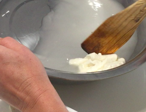 Pala de madera trabajando la masa caliente en el bol